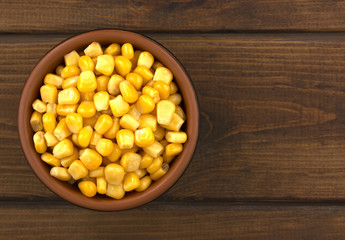 Canned corn  in a bowl on old wooden table