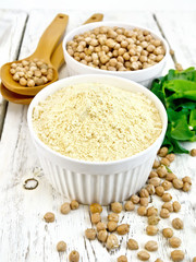 Flour chickpeas in white bowl with peas on light board