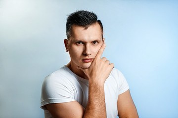 Portrait of a man on a light background close-up. Emotion is the importance, the superiority. The concept of body language, human emotions, reaction.