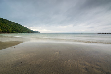 Dramatische Wolken an einem Strand mit Steilküste