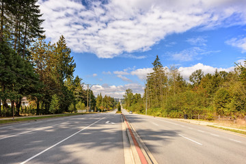 The car goes on the road on the outskirts of the city, in the suburbs