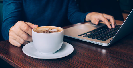 Businessman working with laptop and coffee cup on desk table in cafe shop.Business inspiration