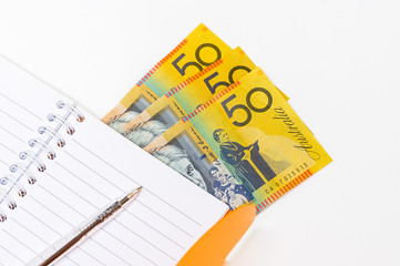 notebook with pen on fifty australian dollar on white