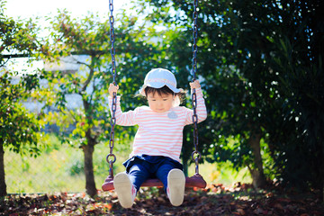 公園の遊具で遊ぶかわいい子供