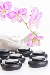 Spa concept with hot stones and burning candle close up