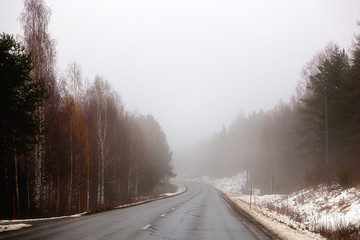 Obraz na płótnie Canvas A deserted highway is in the fog