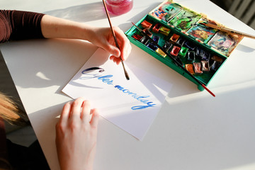 Female calligrapher creates inscription for sale, using brushes 