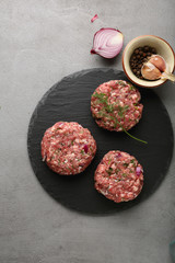 minced meat cutlets on slate background