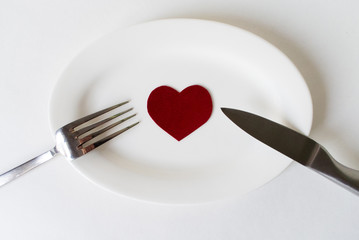 A table setting with dishware and heart on white background . Top view.