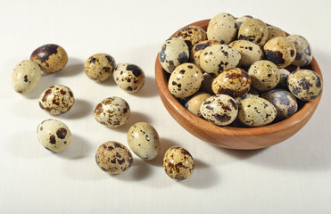 Quail eggs in a wooden bowl in a sacking