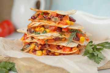 Vegetarian quesadilla with vegetables and cheese on a wooden board