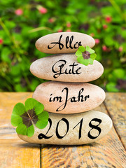 Steinturm und Kleeblätter auf Holz, Alles Gute im Jahr 2018