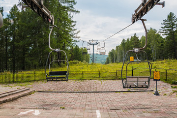 Fototapeta na wymiar Ropeway with open cabins in the mountains