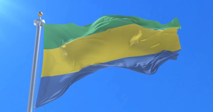 Flag of Gabon waving at wind with blue sky in slow, loop