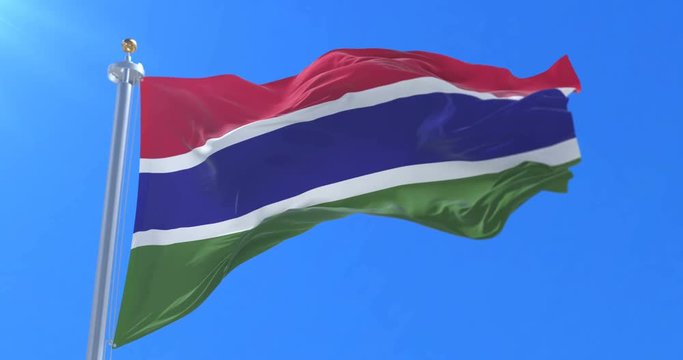 Flag of the Gambia waving at wind in slow in blue sky, loop