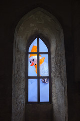 Fototapeta premium Snowman on the sled through a window in the castle