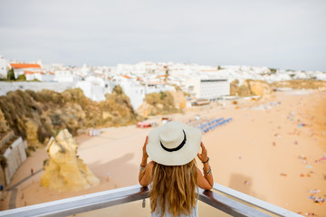 Young woman enjoying beautiful view on the beach in Albufeira town on the south of Portugal