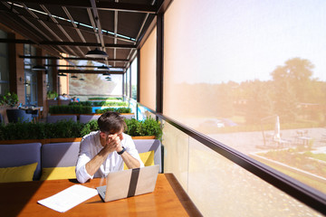 Inventory strategist working with laptop at cafe table.