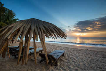 Sun loungers with umbrella on the beach, sunrise