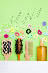 set of different items for styling hair, lies on a green background, there is a place for an inscription