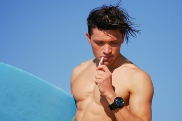 Portrait of 6 packs model young man surfer eating Christmas candy