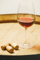 Glass of rum on wooden barrel and a bottle stoppers,