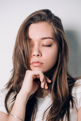 Close up girl. eyes closed. Beautiful woman in white t-shirt, brooding