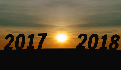 Happy New Year Concept.silhouette sunrise with words 2017 to 2018 on the mountain