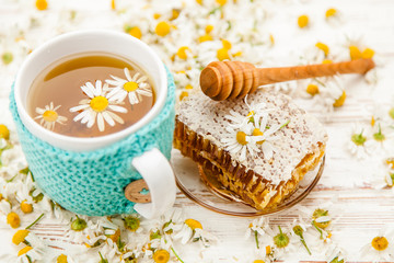 Obraz na płótnie Canvas Honeycomb and chamomile tea on white
