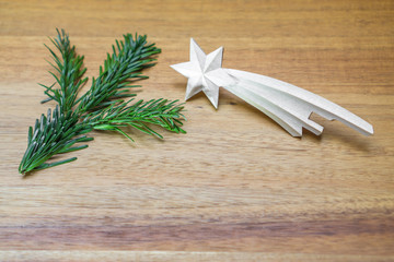 Christmas decoration with fir branch and wooden comet on wooden background