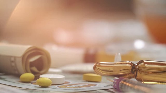 Spoon with cocaine, medicine pills on dollar bank notes. Macro shoot