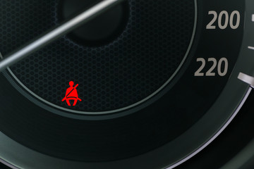 Car Dashboard showing the seat belt warning light