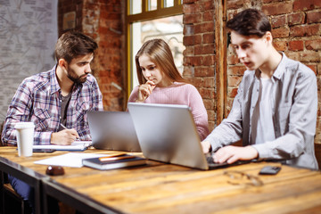 Young creative people working on a business project together.
