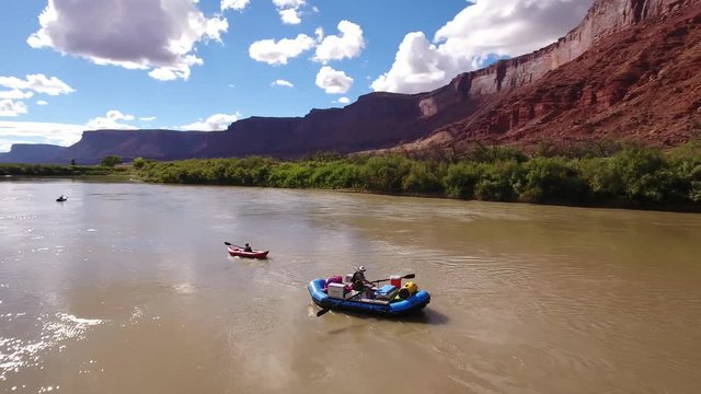 Aerial of family floating down colorado river in dry utah desert