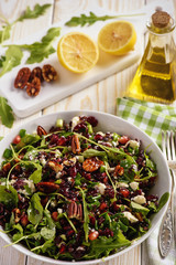 Salad with wild rice, arugula,  pomegranate, pecan nuts, cranberries and feta cheese.