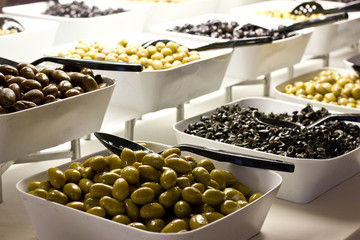 Selection of black and green olives in white bowls