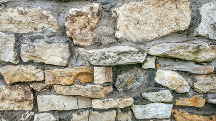 Stone old wall from huge blocks. Background of stones. The concept reliability. The space between stones is filled with cement.