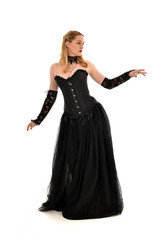 Naklejka premium full length portrait of a blonde girl wearing black gothic gown. standing pose, isolated on white background.