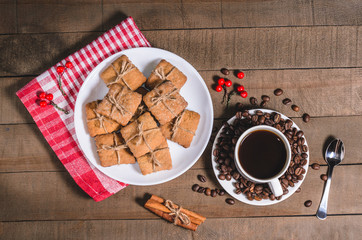 Black coffee in a white cup on a red napkin and homemade cookies.