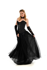Fototapeta premium full length portrait of a blonde girl wearing black gothic gown. standing pose, isolated on white background.