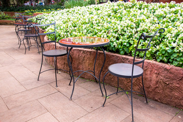 Steel chairs and table in the beautiful garden.