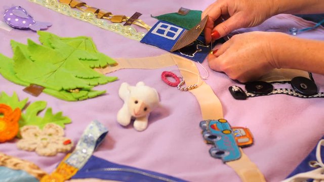 Mother makes soft creative mat for development of child at home