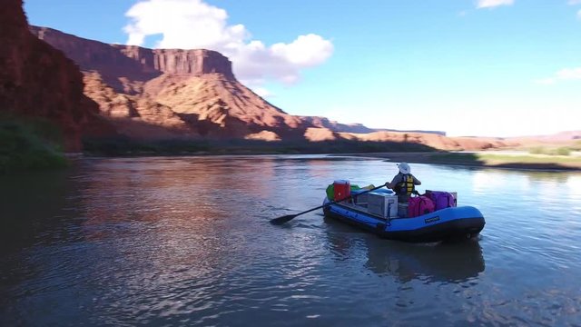 Aerial of man rafting down the desert colorado river in Utah