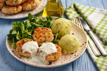 Chicken cutlets served with salad and garlic dip.
