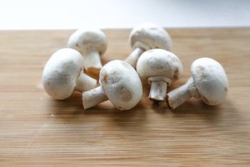 Fresh mushrooms-champignons on a wooden table