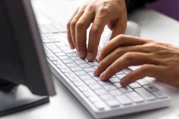 man working in office. close up male hands typing