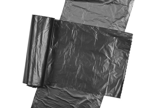 Black roll of plastic garbage bag isolated on white background, top view