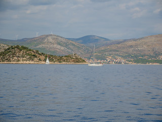 Croatian coastline with wind power generators on hills.