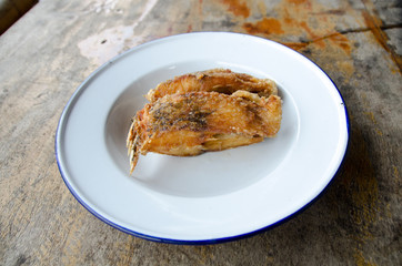 Delicious Asian fish fry served on a wooden table.