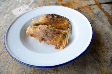 Delicious Asian fish fry served on a wooden table.